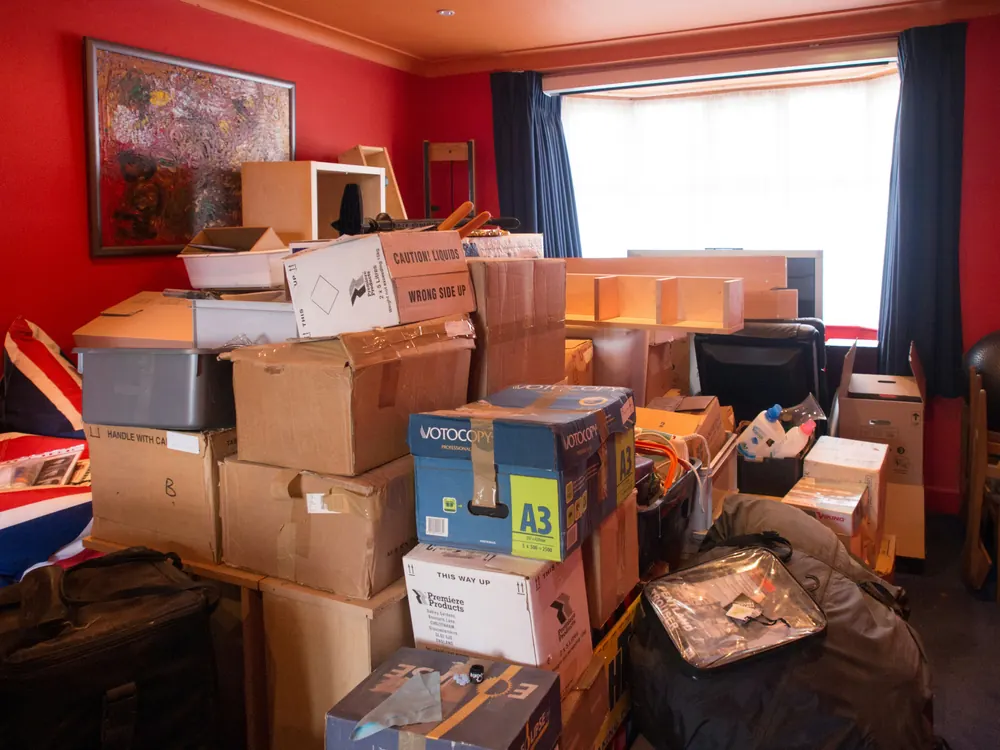 Nachlassräumung in München: Wohnzimmer mit gepackten Kartons und Hausrat vor der Räumung